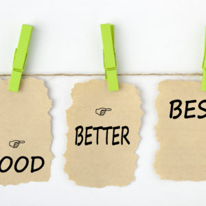 GOOD BETTER BEST writen on old torn paper with clip hanging on white background. Business concept words.